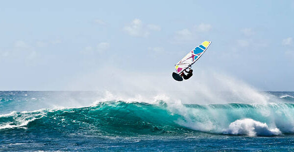 Windsurfer flying over wave.